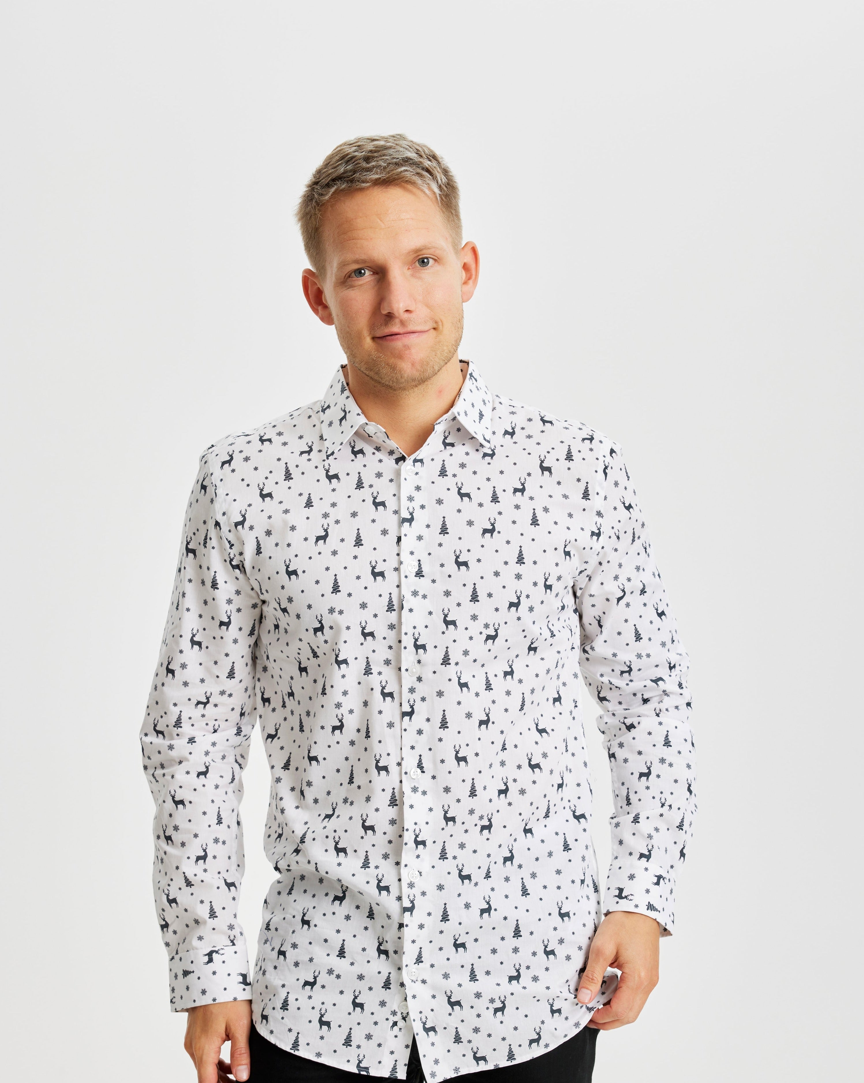 Ein lächelnder Mann trägt ein weißes Weihnachtshemd mit einem Weihnachtsmuster.